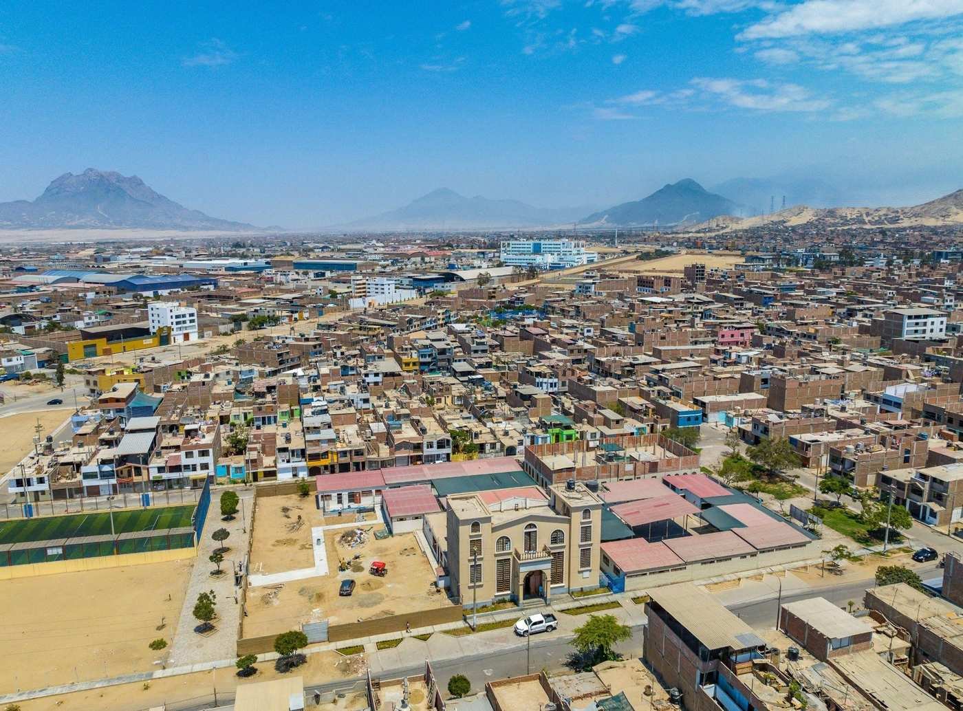 Vista a&eacute;rea de un barrio de casas bajas de ladrillo, con los cerros de fondo