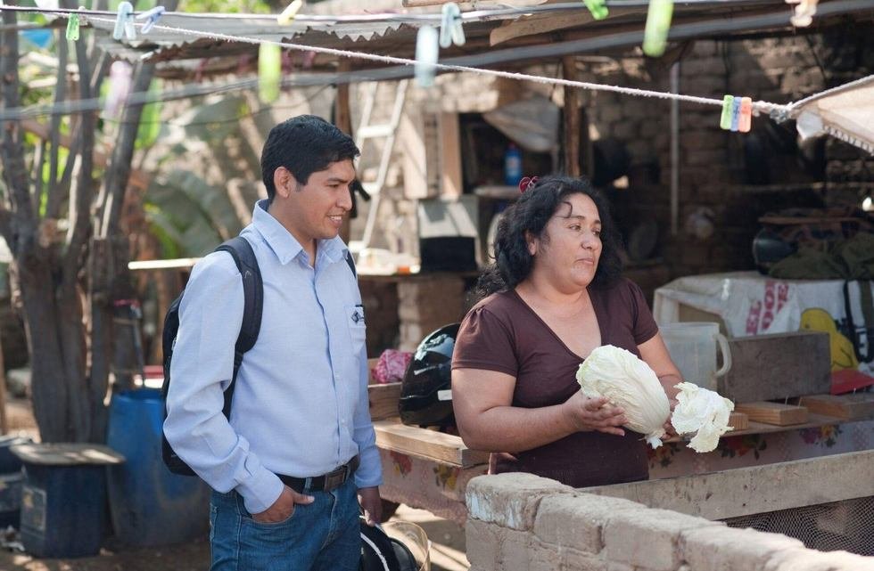 Un promotor conversa con una se&ntilde;ora en su puesto de quesos