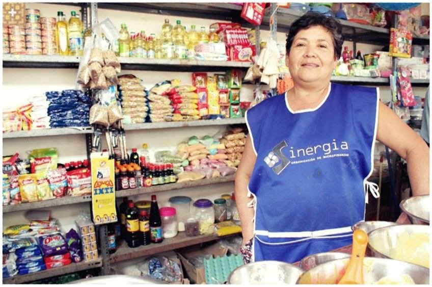 Una socia detr&aacute;s del mostrador de su bodega, con el mandil de la cooperativa
